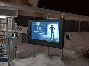 A 55" outdoor digital signage enclosure installed at the base of a ski-lift in a snowy setting